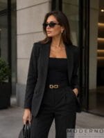 Model nosi crni ženski kožni pojas sa zlatnom šnalom - elegantan modni detalj