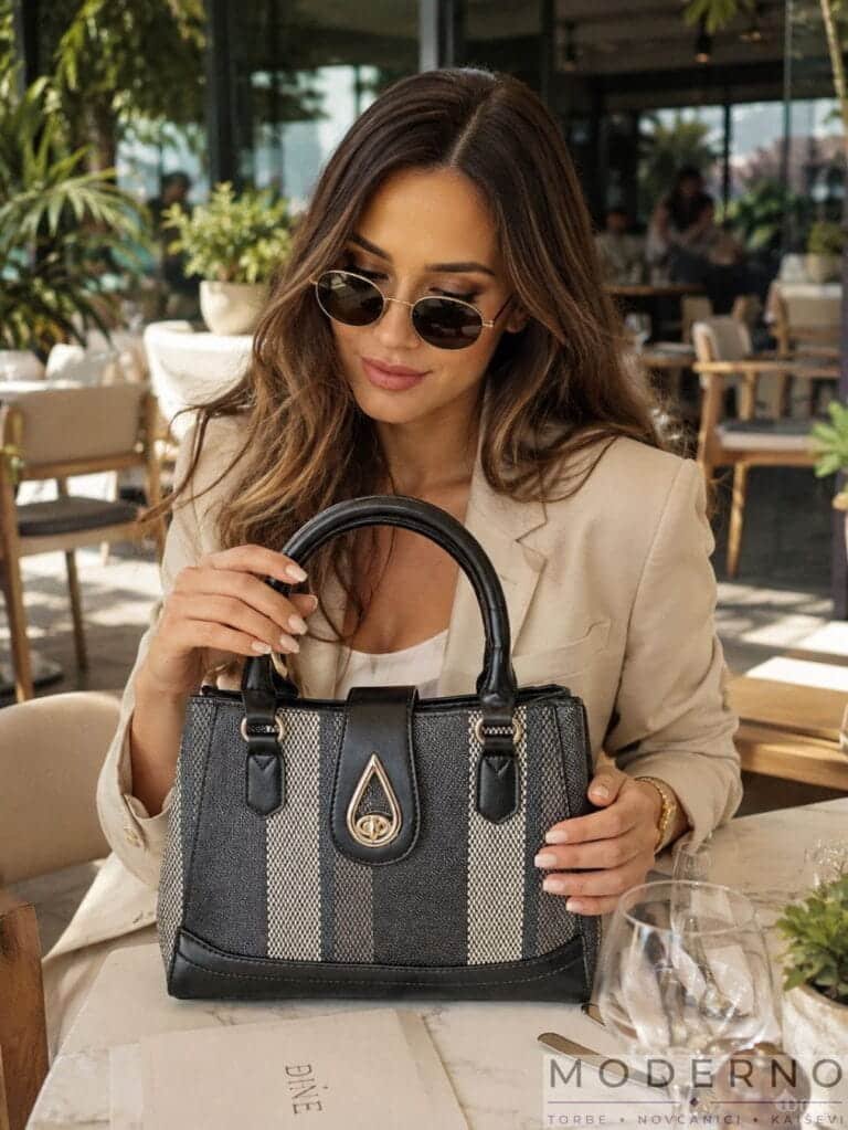 ženski set “Tina” torba i novčanik crni sa sivim šarama model drži torbu u kafiću
